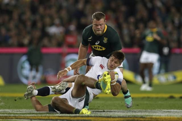 England's Piers Francis, centre, is tackled by South Africa's Damian de Allende at Ellis Park on Saturday. Picture: AP/Themba Hadebe