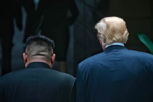 U.S. President Donald Trump, right, and North Korean leader Kim Jong Un walk together during their meeting at the Capella resort on Sentosa Island Tuesday, June 12, 2018, in Singapore. (Kevin Lim/The Straits Times via AP)