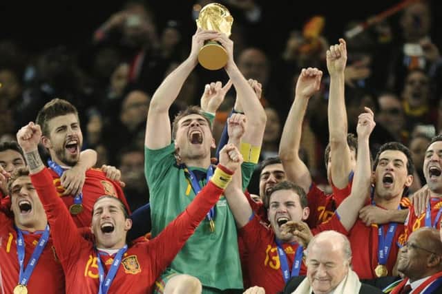 Spain goalkeeper Iker Casillas, center, holds up the World Cup trophy.