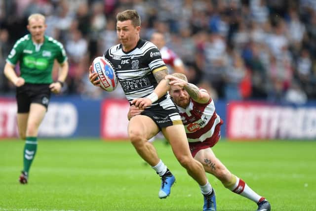 Hull FC's Jamie Shaul is tackled by Wigan Warriors' Sam Tomkins at the KCOM Stadium. Picture: Dave Howarth/PA