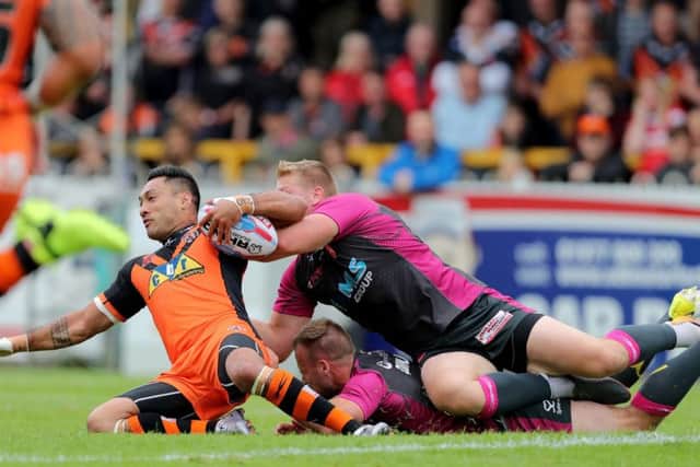 Castleford Tigers Quentin Laula-Togaga'e is tackled by a dogged Hull KR defence. Picture: Richard Sellers/PA