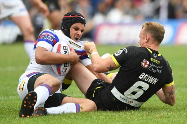Wakefield Trinity's Ben Jones-Bishop is tackled by Warrington Wolves' Kevin Brown. Picture: Anna Gowthorpe/SWpix.com