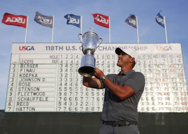Winner: Brooks Koepka holds up the tophy after retaining his US Open title. Picture: AP Photo/Carolyn Kaster