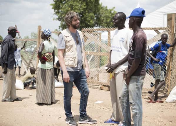 Benson Taylor with South Sudanese refugees at a World Food Programme food distribution site. Picture: Hugh Rutherford