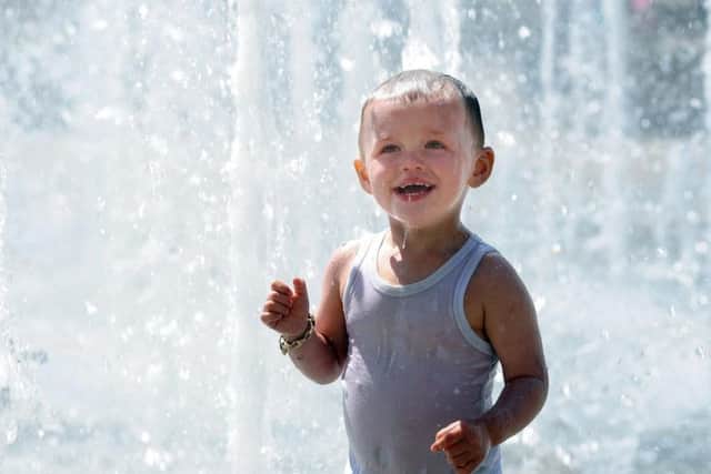 Two year old Kohen Yates cools off in the fountains in Sheffield's Peace Gardens