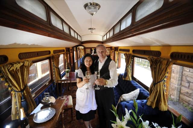 Steve Middleton with his wife Qiuying, on the restored Victorian carriage at Embsay Station. Picture by Simon Hulme