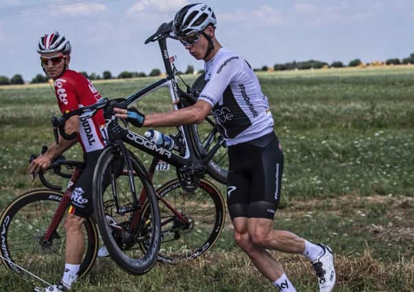 Britain's Chris Froome, right, and Belgium's Jasper De Buyst, left, get back on the road after crashing during the first stage of the Tour de France  (Jeff Pachoud, pool photo via AP)