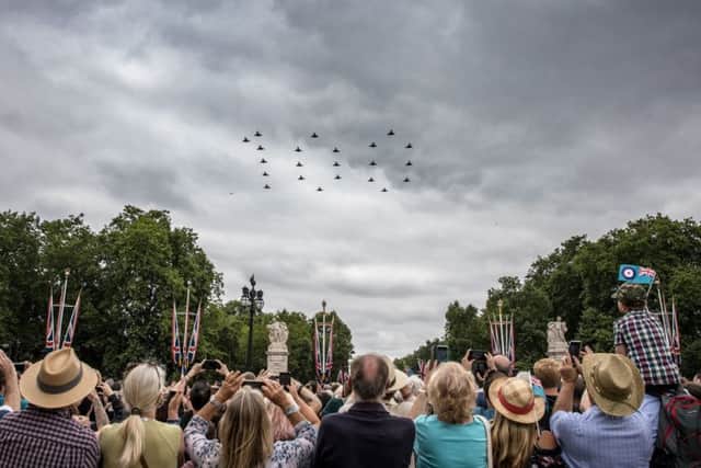Thousands of people watch the RAF flypast in London.