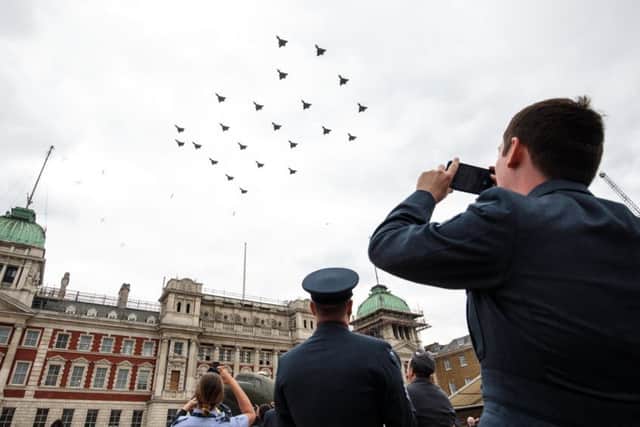 Members of the Royal Air Force watch the Typhoon FGR4 aircraft flypast over Horse Guards Parade during RAF 100 celebrations on July 10, 2018 in London, England.