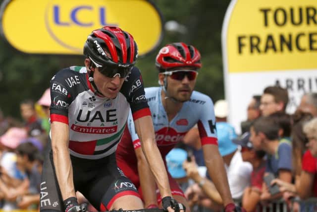Ireland's Daniel Martin, left, crosses the finish line with more than a minute delay on his main opponents after crashing during the eight stage of the Tour de France. (AP Photo/Peter Dejong)
