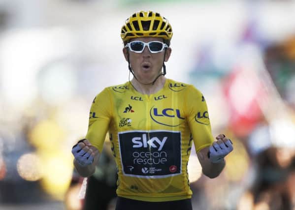 Britain's Geraint Thomas, wearing the overall leader's yellow jersey, celebrates as he crosses the finish line to win the 12th stage of the Tour de France (Picture: Christophe Ena/AP).