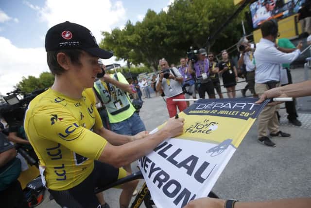 Britain's Geraint Thomas, wearing the overall leader's yellow jersey, signs the start flag prior to the fifteenth stage of the Tour de France. Picture: AP/Christophe Ena