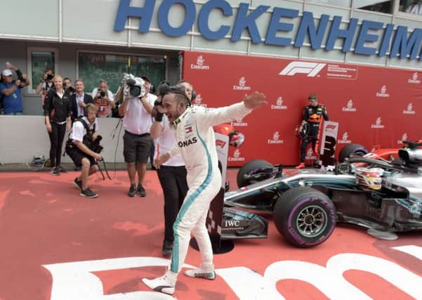CATCH ME IF YOU CAN: Lewis Hamilton celebrates after winning the German Formula One Grand Prix at the Hockenheimring racetrack in Hockenheim. Picture: AP/Jens Meyer