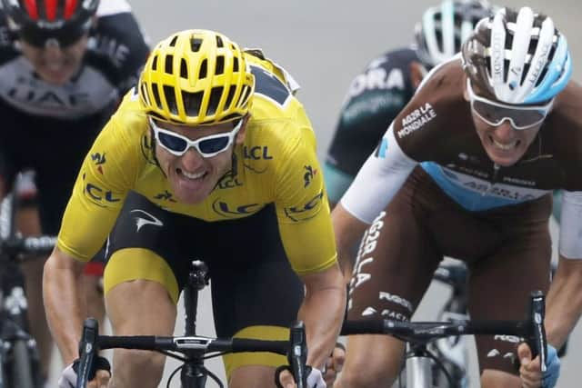 Britain's Geraint Thomas, wearing the overall leader's yellow jersey, grimaces as he sprints with France's Romain Bardet, right, towards the finish line of the 19th stage of the Tour de France. Picture: AP/Peter Dejong
