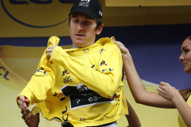 SO CLOSE: Britain's Geraint Thomas puts on the overall leader's yellow jersey after the nineteenth stage of the Tour de France yesterday. Picture: AP/Christophe Ena