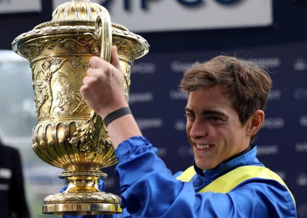 Victory: Jockey James Doyle poses with the trophy after winning the King George VI And Queen Elizabeth Stakes.