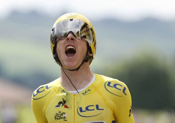 Joy: Britain's Geraint Thomas crosses the finish line at the 20th stage .