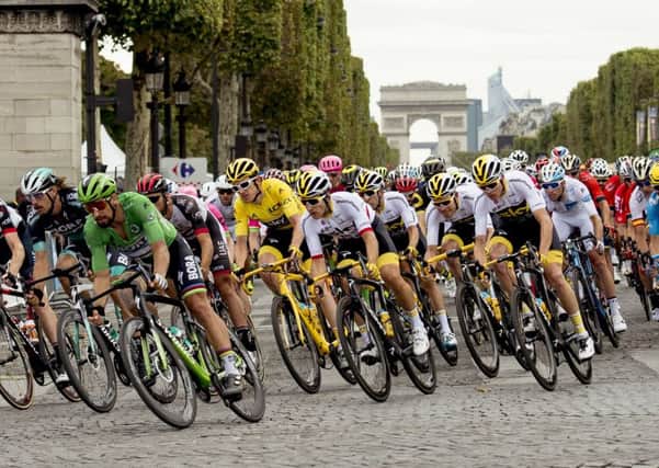 Tour de France winner Geraint Thomas, of Britain, wearing the overall leaders yellow jersey, and Slovakias Peter Sagan, wearing the best sprinters green jersey, ride down Champs Elysees avenue on the final stage with the Arc de Triomphe seen in the background (Picture: Francois Mori/AP).
