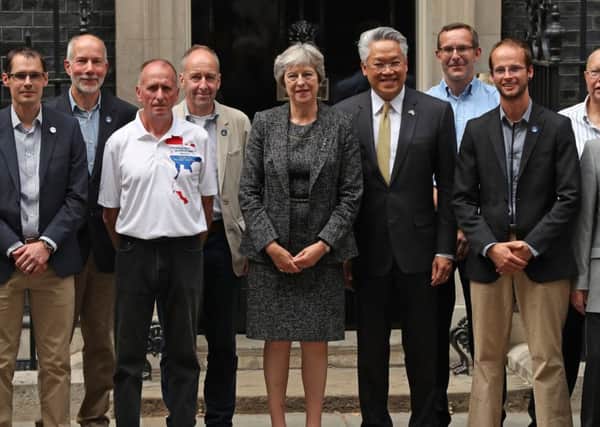 Prime Minister Theresa May (centre) with the Thai Ambassador Pisanu Suvanajata (centre right) in Downing Street, London with the divers and support team from the British Cave Rescue Council who joined the rescue of the 12 schoolboys and their football coach from a flooded cave in Thailand.