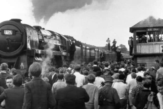 Thousands of people straining to get a look at Britain's last mainline steam passenger train as it passed through Rainhill station, between Liverpool and Manchester. PIC: PA