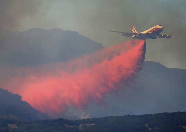 A 747 Global air tanker makes a drop on a wildfire in Scotts Valley. PIC: AP