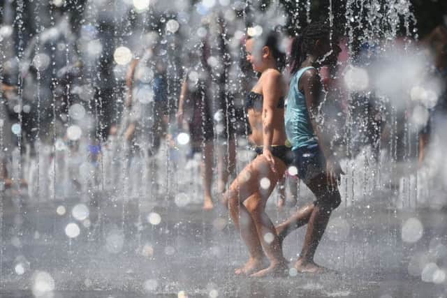 Children play in the fountains at Granary Square, King's Cross, during the heatwave