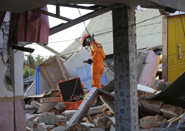 A rescue team searches for victims in the rubble caused by an earthquake in North Lombok, Indonesia. PIC: AP