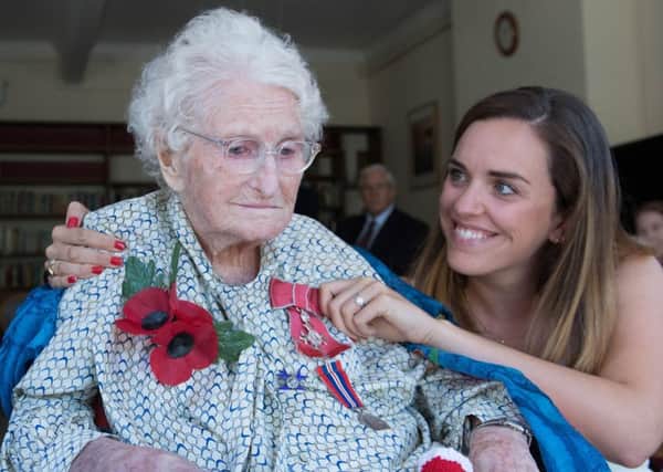 Britain's longest-serving poppy seller, 103-year-old Rosemary Powell, with grand daughter Celia Speller, after she was presented with an MBE at her retirement home. PIC: PA
