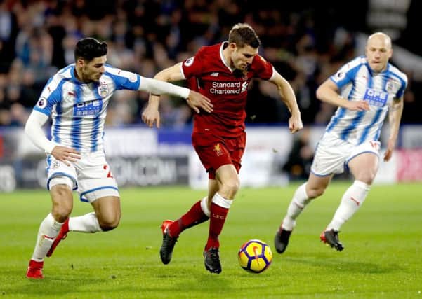 Liverpool's James Milner (centre) and Huddersfield Town's Christopher Schindler (left) battle for the ball during the Premier League match last season (Picture: PA)