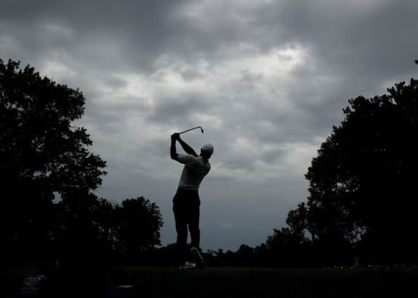 Tiger Woods tees off on the second hole during practice for the US PGA Championship at Bellerive as the storm clouds gather (Picture: Charlie Riedel/AP).