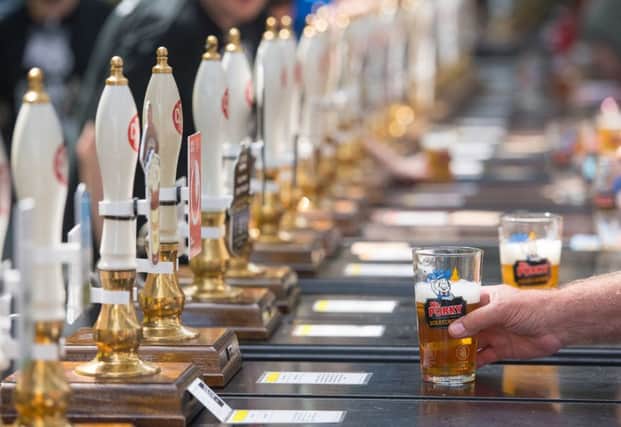 A visitor buys a drink during the Great British Beer Festival in London