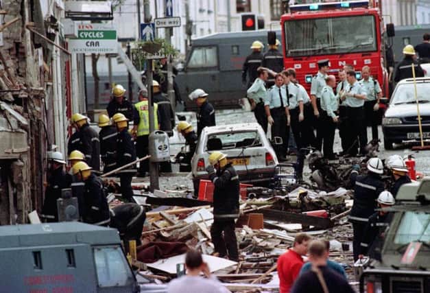 Police and firefighters inspecting the damage caused by a bomb explosion in Market Street, Omagh.
