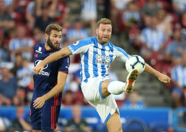 Fighting for his place: Huddersfield Town's Laurent Depoitre, right, challenged by Lyon's Lucas Tousart.