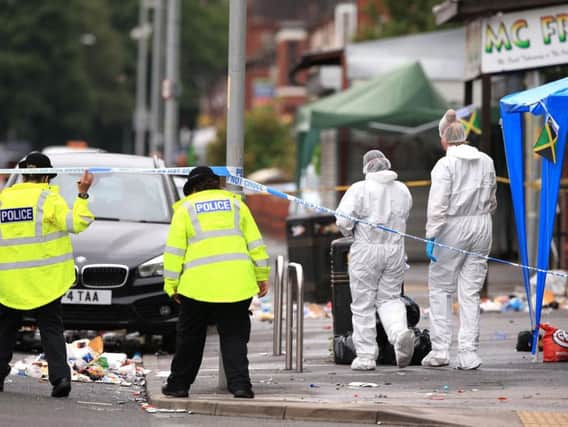 Police at the scene of the shooting in Moss Side, Manchester