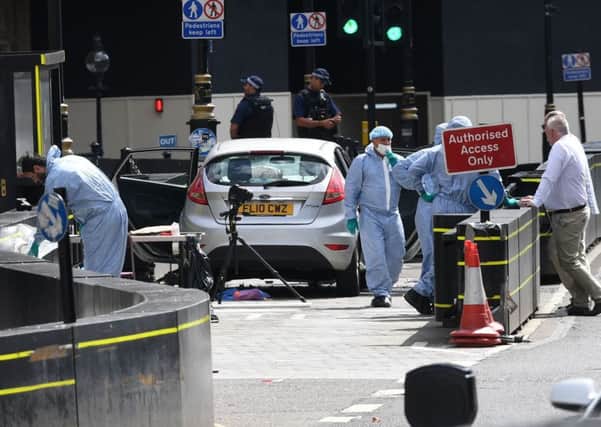 Forensic officers by the car that crashed into security barriers outside the Houses of Parliament, Westminster, London. PRESS ASSOCIATION Photo.