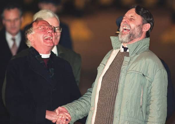 Archbishop of Canterbury shares a joke with released hostage Terry Waite when he returns to RAF Lyneham November 22, 1991 after being held for more than four years in captivity in Beirut. PA.