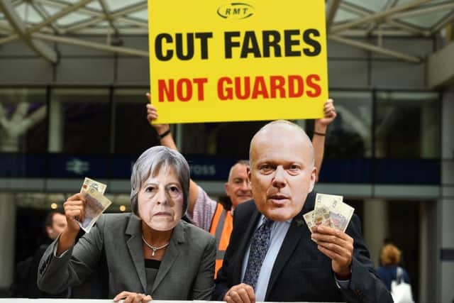 Protesters dress up as Prime Minister Theresa May and Transport Secretary Chris Grayling during a protest at rising rail fares.