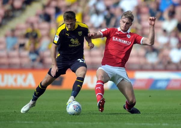 Barnsley's Liam Lindsay, right, in action against Oxford United's James Henry (Picture: Tony Johnson).