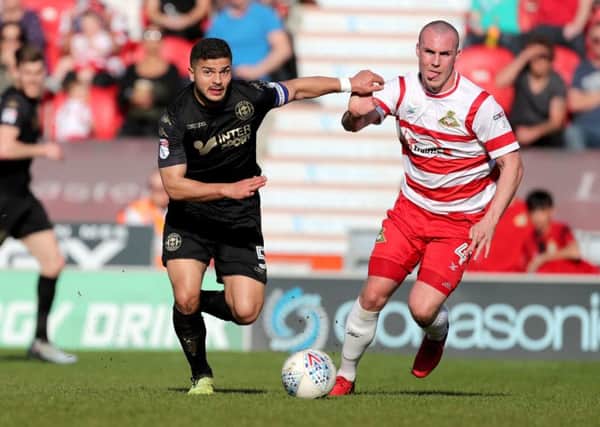 Doncaster Rovers' Luke McCullough, right, challenges Wigan's Sam Morsy (Picture: Richard Sellers/PA Wire).