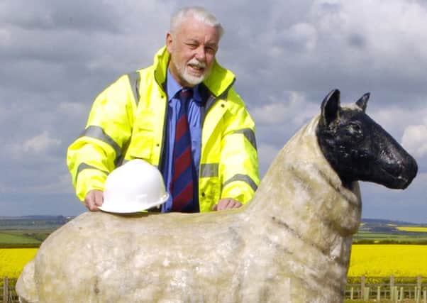 Ronald Falck with one of his sheep sculptures on the southern end of the Reighton bypass