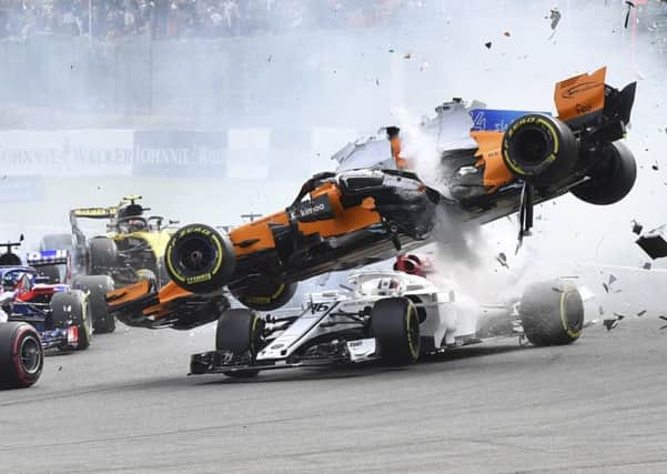 CRASH: McLaren driver Fernando Alonso goes over the top of Sauber's Charles Leclerc at the start of the Belgian Grand Prix in Spa-Francorchamps. Picture: AP/Geert Vanden Wijngaert