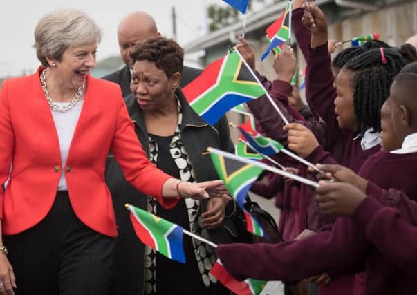 Theresa May has signalled a change in approach to overseas aid spending during a visit to South Africa.
