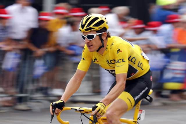 Tour de France winner Britain's Geraint Thomas, wearing the overall leader's yellow jersey speeds down the Champs Elysees. (AP Photo/Laurent Rebours)