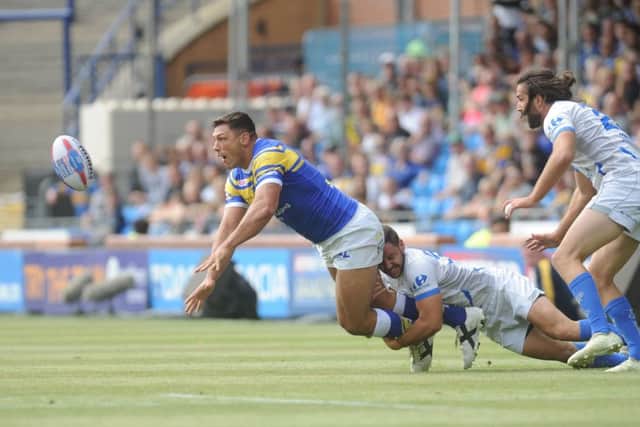 LAST OUTING: 
Ryan Hall passes while being tackled in the Qualifiers clash with TOulouse - his last appearance in a Leeds Rhinos' shirt. Picture: Steve Riding.