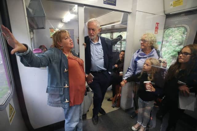 Labour leader Jeremy Corbyn talks to Patricia Russell, watched by mother Jane and daughters Leah, 11 and Chloe, seven, on a train from Manchester Victoria Station to Leeds, as he travels the route of Crossrail for the North. PRESS ASSOCIATION Photo.