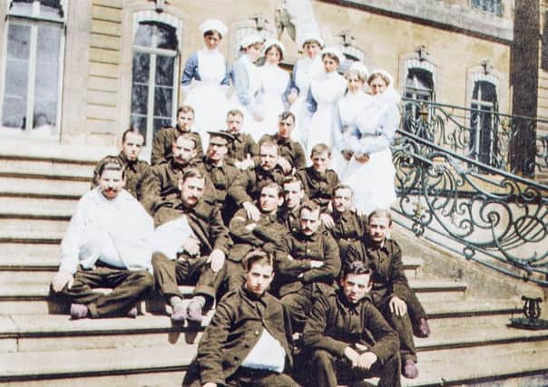 Nurses and convalescents on the terrace steps at Wrest Park, Christmas 1914.