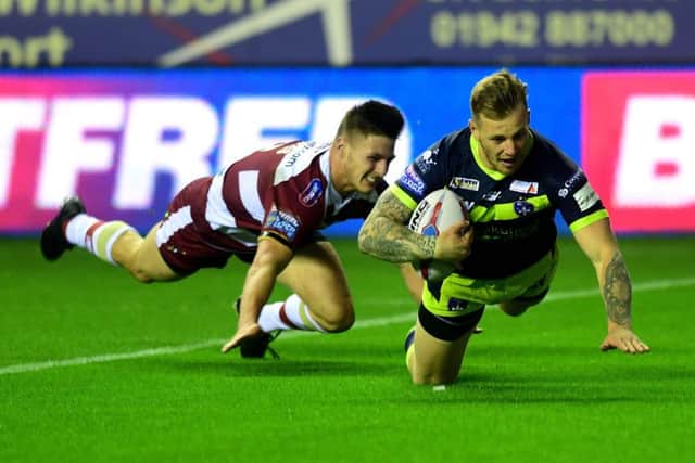 Wakefield's Tom Johnstone beats Wigan's Thomas Davies to score his side's opening try.