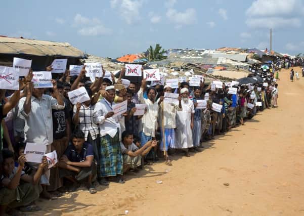 Rohingya refugees holing placards, await the arrival of a U.N. Security Council team at the Kutupalong Rohingya refugee camp in Kutupalong, Bangladesh.