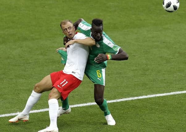Hull City's Polish international Kamil Grosicki, left, seen duelling with Senegal's Salif Saneduring the  World Cup in June 19 (Picture: Themba Hadebe).