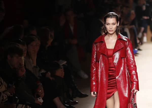 RED ALERT: Red gets textural for autumn, as seen here modelled by  Bella Hadid at the Roberto Cavalli show in Milan. Layer matt and shine red  and experiment with shapes and length to get the look right. If you see anything in red snake leather, snap it up. (AP Photo/Antonio Calanni)